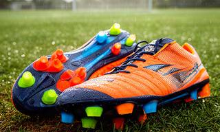 Soccer cleats with bright studs placed on a damp Florida training pitch